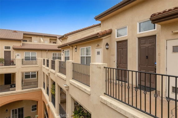 Front view of a multi-story building with balconies and brown doors.