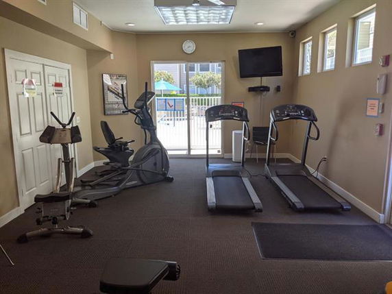 Indoor gym area with exercise equipment including treadmills and a stationary bike.