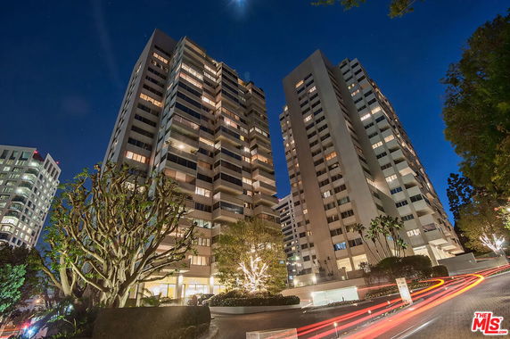 Front view of a high-rise building with multiple floors at night.