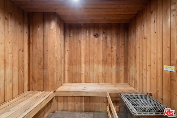Interior view of a wooden sauna room with benches and a heater.