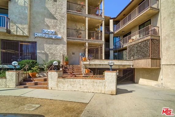 Front view of a multi-story building with balconies and staircases.