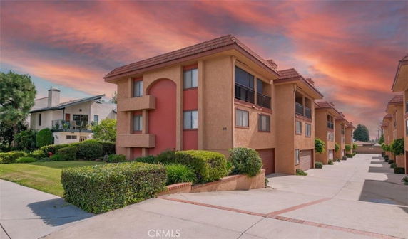 Front view of a multi-story apartment building complex with a driveway.