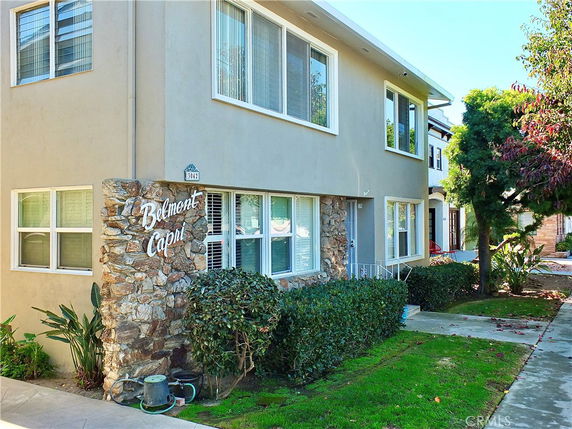 Front view of a two-story apartment building with stone accents and large windows.