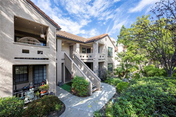 Front view of a two-story residential building with balconies and a tiled roof.
