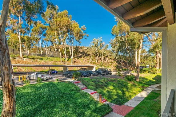 Outdoor parking area with covered spaces and cars parked.