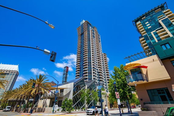 Front view of a tall apartment building with multiple balconies in an urban setting.