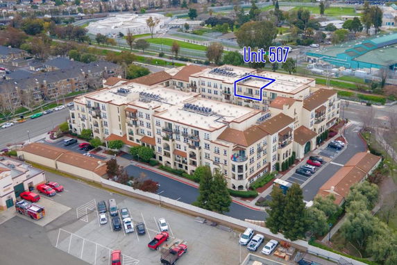 Front view of a multi-story apartment complex with a marked unit.