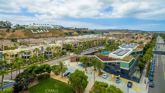 Panoramic view of a residential area with multiple buildings and a main road.