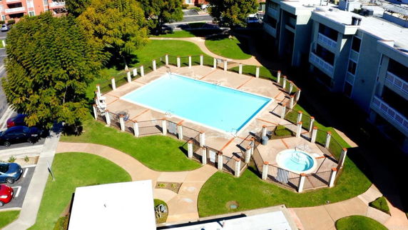 Aerial view of an outdoor swimming pool area within a residential complex.