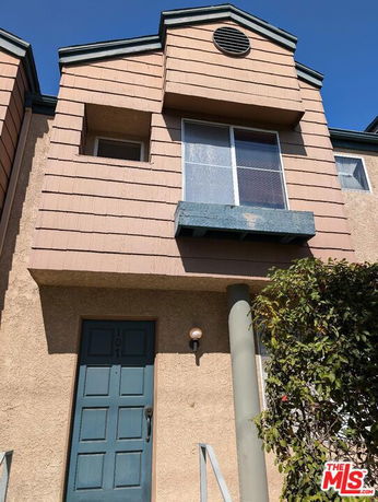 Front view of a two-story house with a blue door and large window.