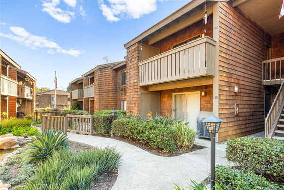 Front view of apartment complex with wood siding and balconies.
