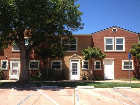 Front view of a two-story townhouse with red brick and beige exterior.