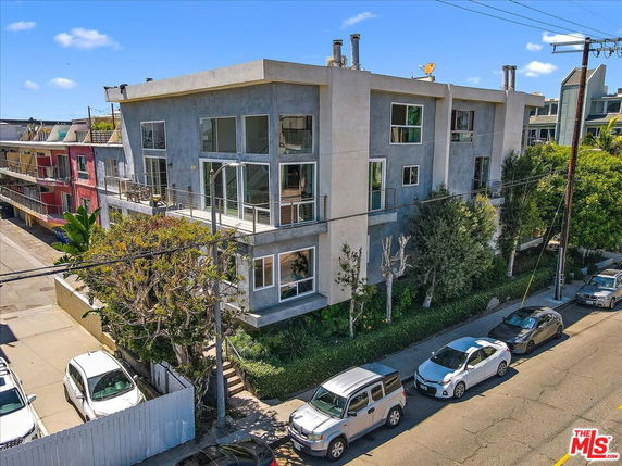 Front view of a multi-story residential building with large windows and balconies.