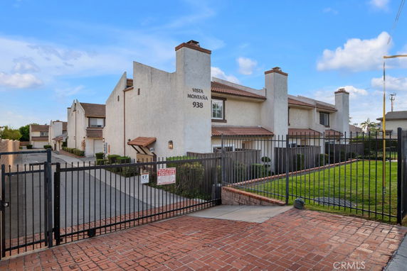 Front view of a multi-story residential building with a gated entrance.