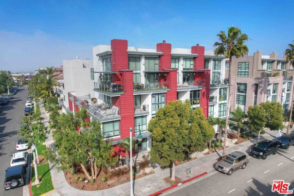 Front view of a modern multi-story apartment building with balconies.