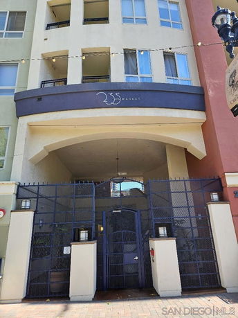 Front view of a multi-story residential building with a gated entrance.
