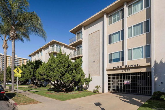 Front view of a multi-story apartment building with balconies.