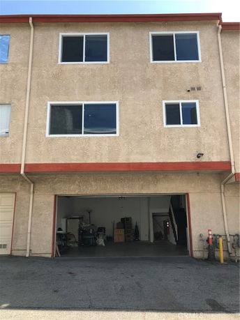 Front view of a multi-story building with a large open garage space.