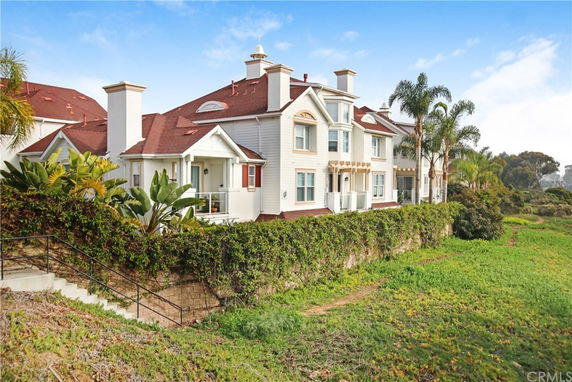 Front view of a two-story house with red roofs and white exterior.