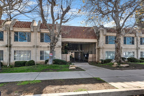 Front view of a two-story building with a central entrance and a tiled roof.