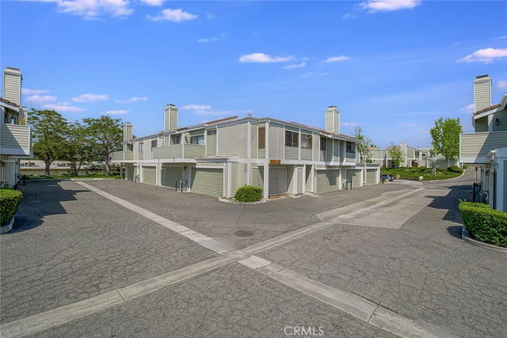 Front view of a two-story residential building with attached garages and chimneys.