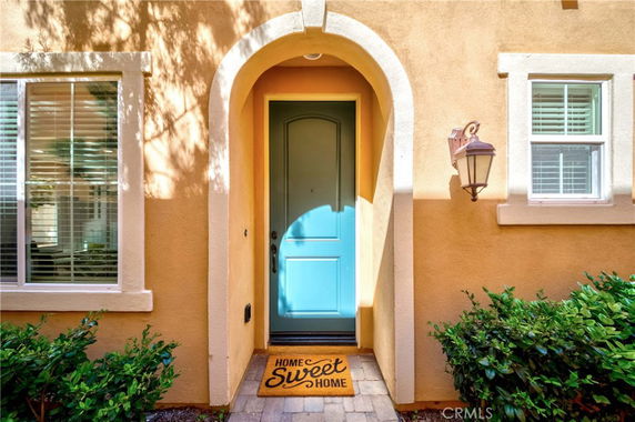 Front view of a house with a blue door and arched entryway.