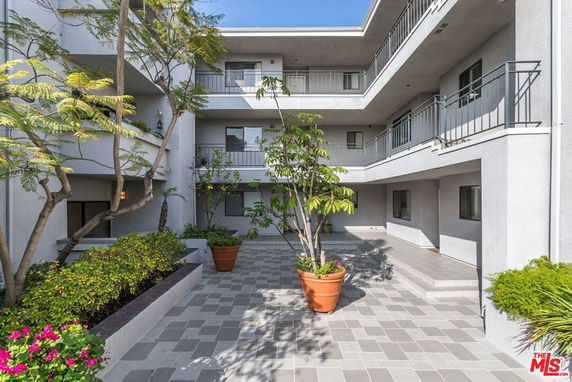 Front view of a multi-story building with a courtyard and balconies.