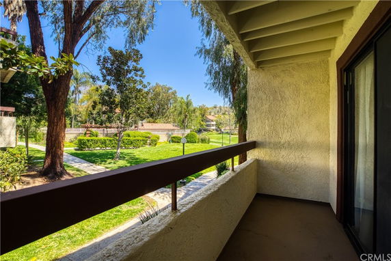 Balcony view overlooking a garden with trees and a pathway.
