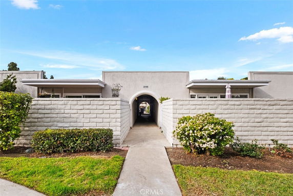 Front view of a single-story house with brick walls and an arched entrance.