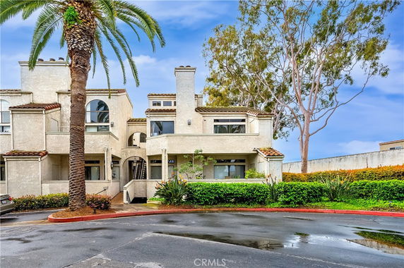 Front view of a multi-story house with a modern architectural design and arched windows.