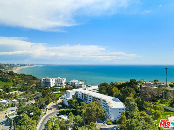 Panoramic view of the coastline with residential buildings overlooking the ocean.
