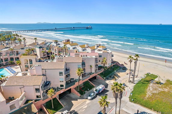 Coastal buildings with ocean and pier in the background.