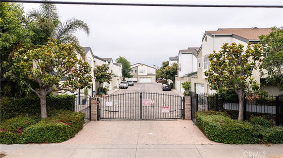 Front view of a gated residential area with multiple two-story houses.