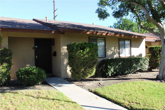 Front view of a single-story house with a small walkway and modest landscaping.