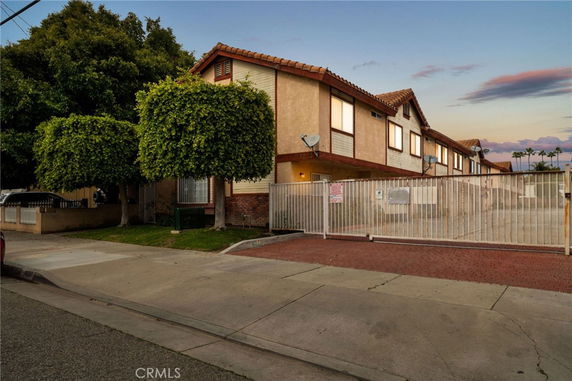Front view of a two-story residential building with a gated entrance.