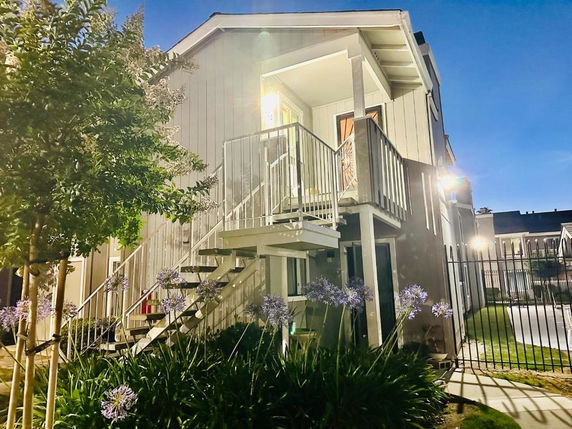 Front view of a two-story building with exterior stairs and a small balcony.