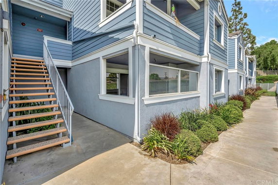 Front view of a blue two-story building with a staircase leading to the upper level.