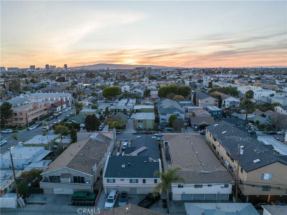 Panoramic view of residential area at sunset with multiple houses and buildings.