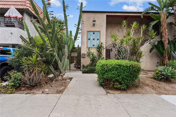 Front view of a house with a gated entrance and desert landscaping.