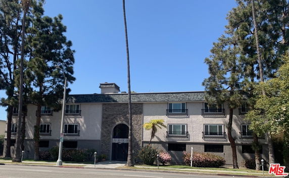 Front view of a three-story residential building with multiple windows and a central entrance.