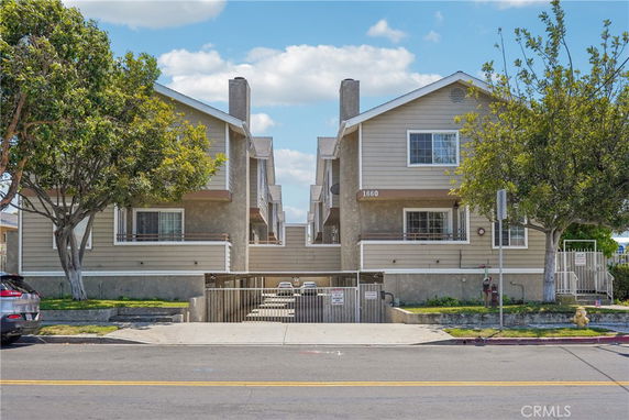 Front view of a two-story residential building with a symmetrical design and two gable roofs.