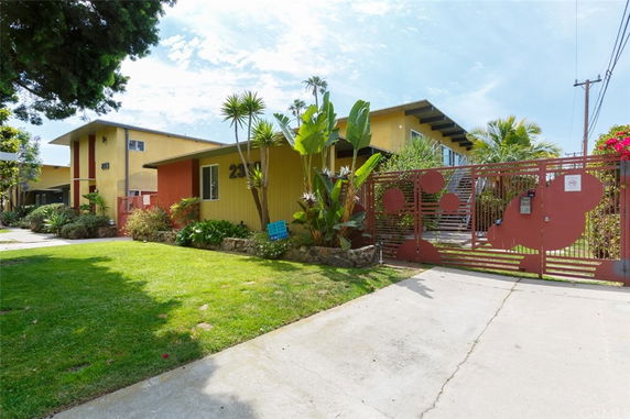 Front view of a multi-unit residential building with a gated entrance.