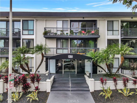 Front view of a multi-story residential building with balconies.