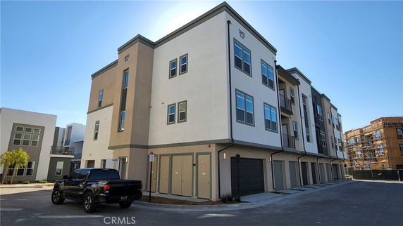 Front view of a multi-story apartment building with garages.
