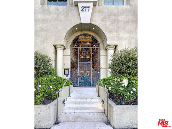 Front view of a building entrance with an ornate metal gate and arched doorway.