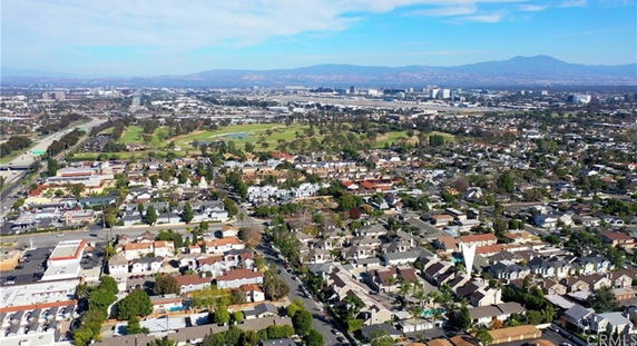 Wide-angle aerial view of a residential and urban area with houses and buildings.