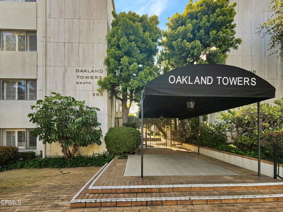 Front view of a multi-story building entrance with a canopy labeled 'Oakland Towers'.