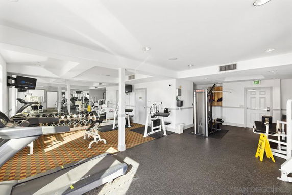 Indoor gym area with exercise equipment and mirrors.