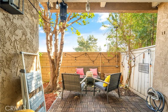 Outdoor patio area with seating arrangements and wooden flooring.