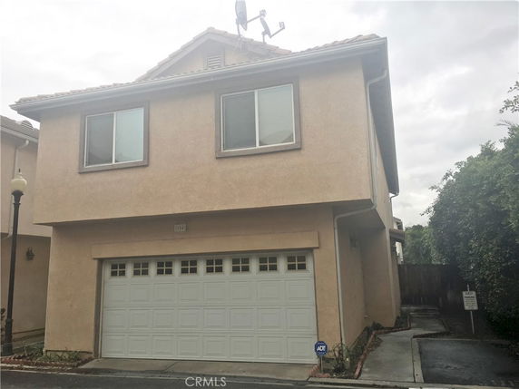 Front view of a two-story house with a garage and windows.